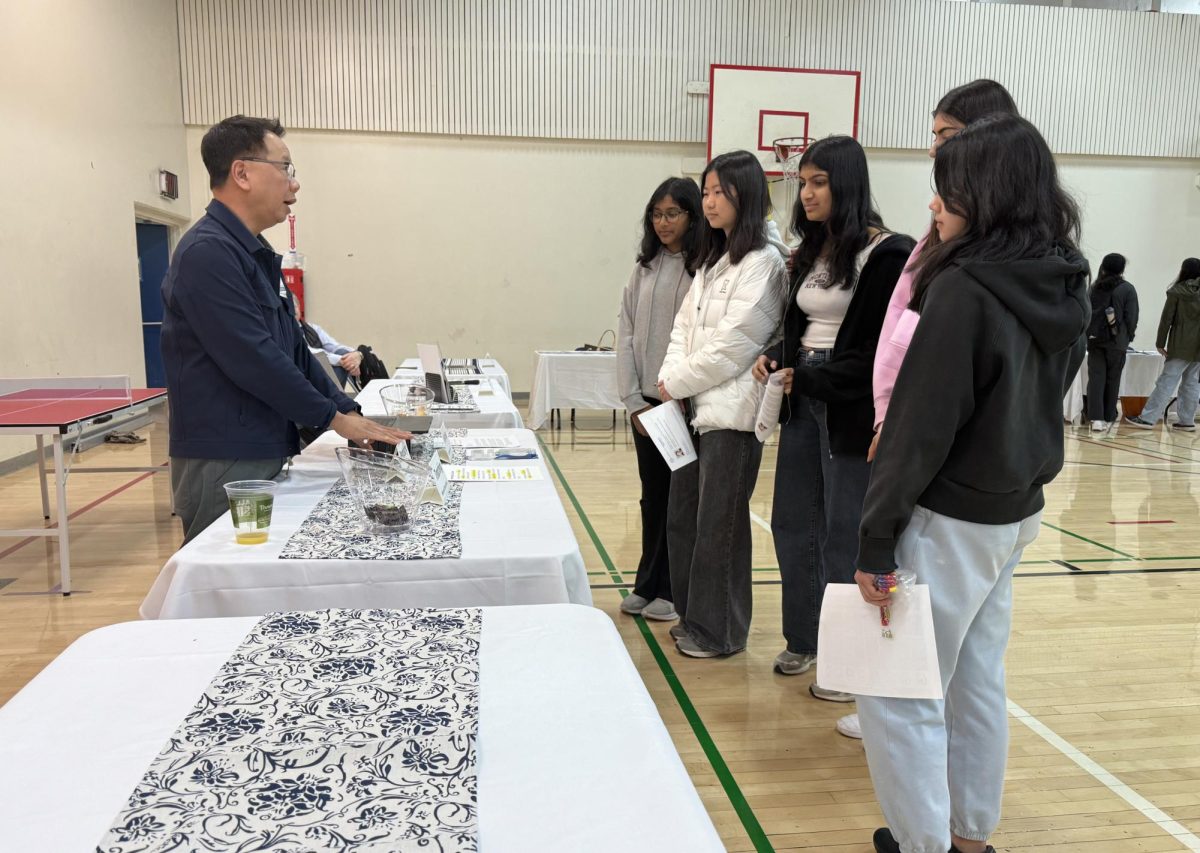 Nick Nguyen, the father of sophomores Chloe, Lauren and Noah Nguyen, explains his occupation as a prosthodontist and his career journey to a group of students at the career fair. 