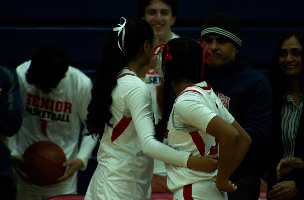 After the senior night game, the Iyer’s sisters share a special moment.