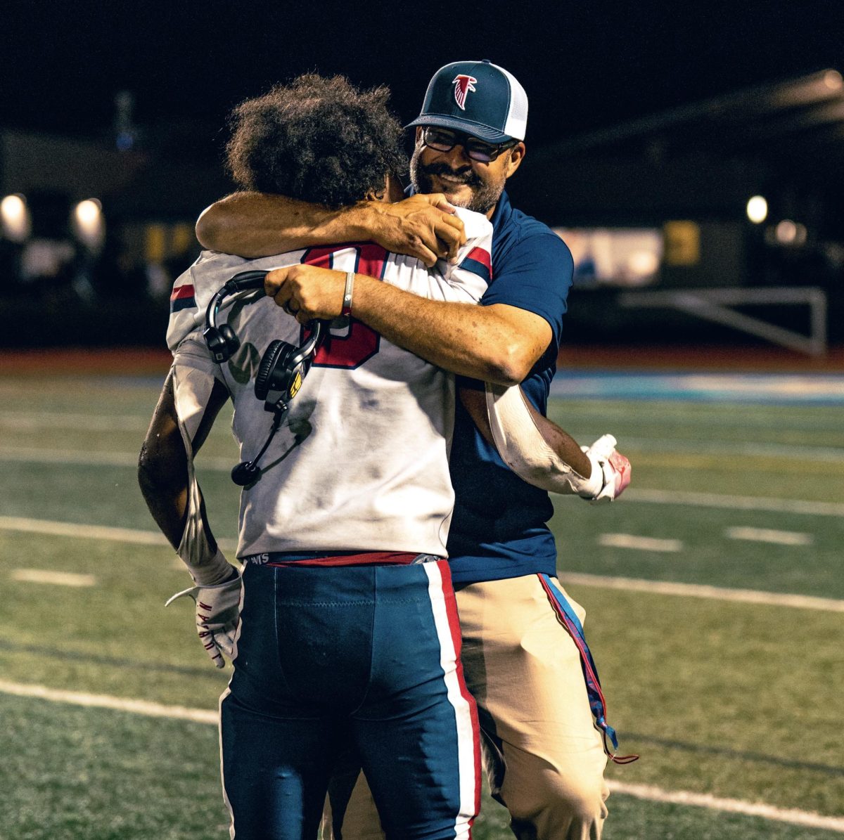 Archie Ljepava hugging alumnus Keion Ashjaee-Marshall after a close football win.