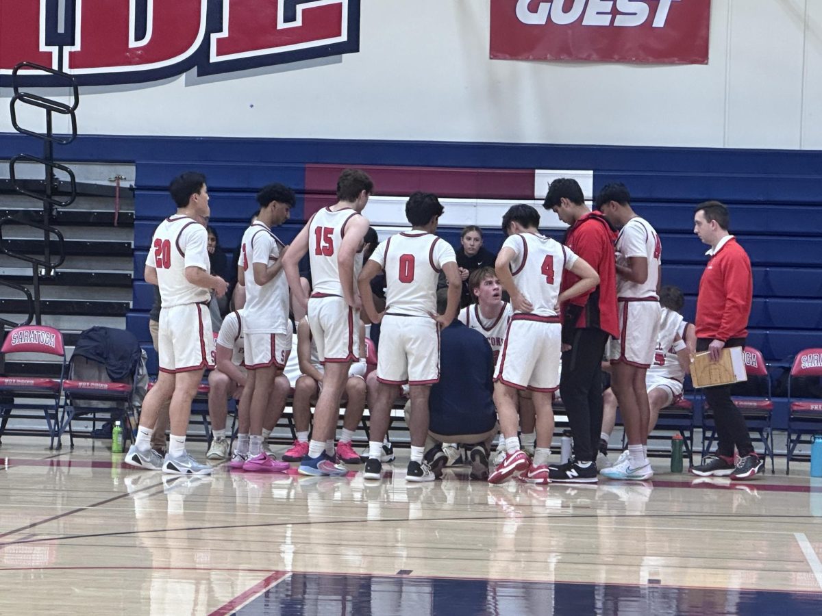 The boys’ basketball team circles around head coach Mike Davey after the first quarter to discuss strategies against the Los Altos Eagles on Jan. 3.
