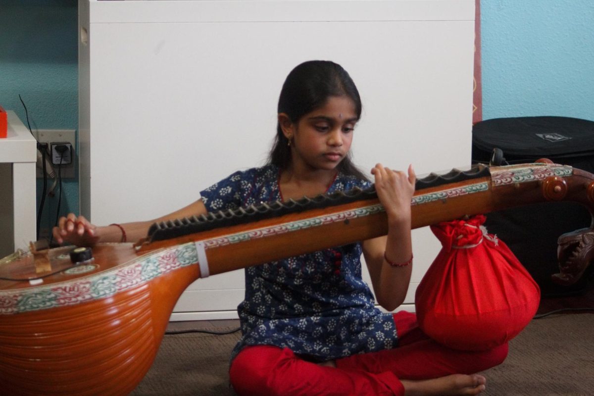  Courtesy of Aditi Balepur
A 9-year-old Balepur practices the veena in her home. 
