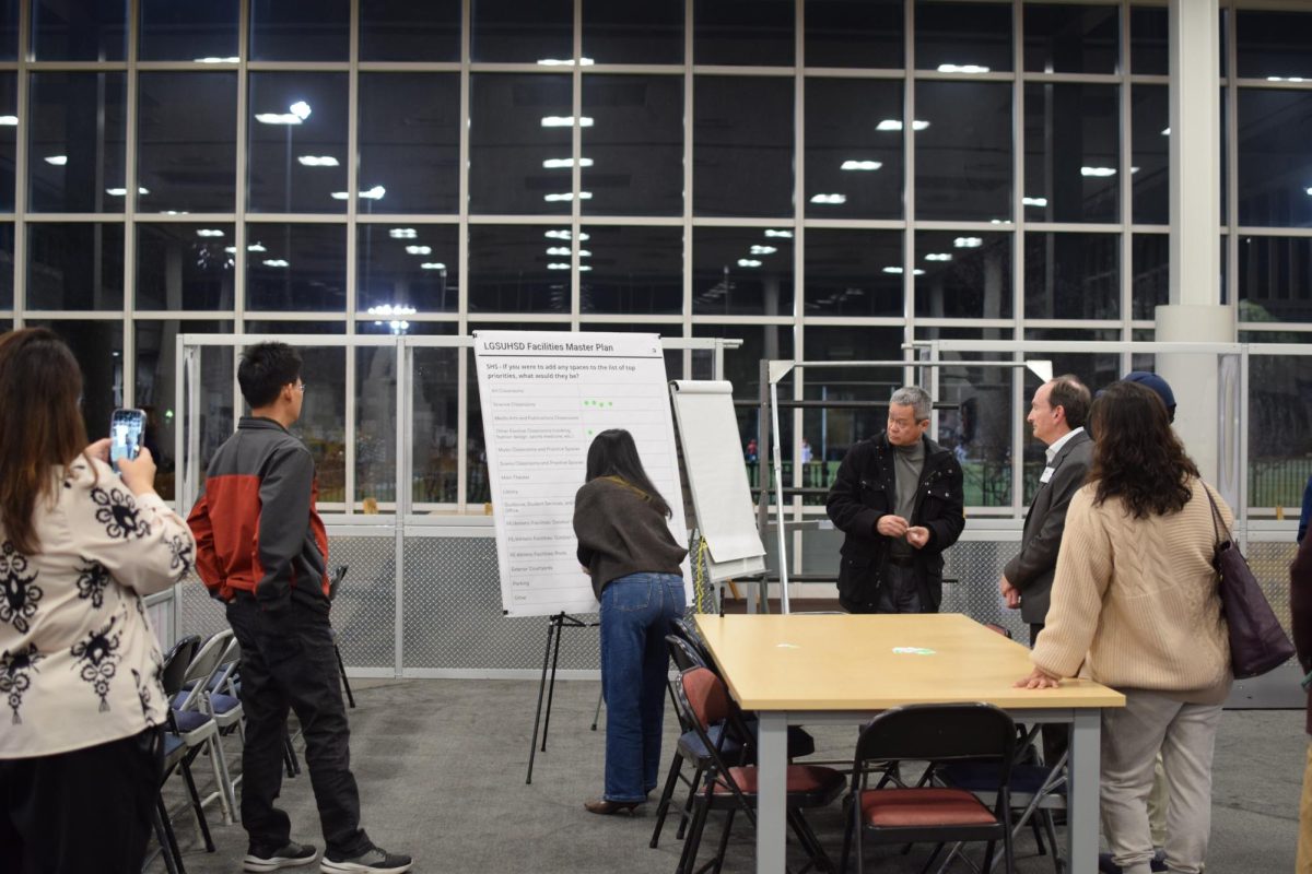 Parents gather around a discussion board to mark their concerns during a Feb. 23 community meeting in the library. 