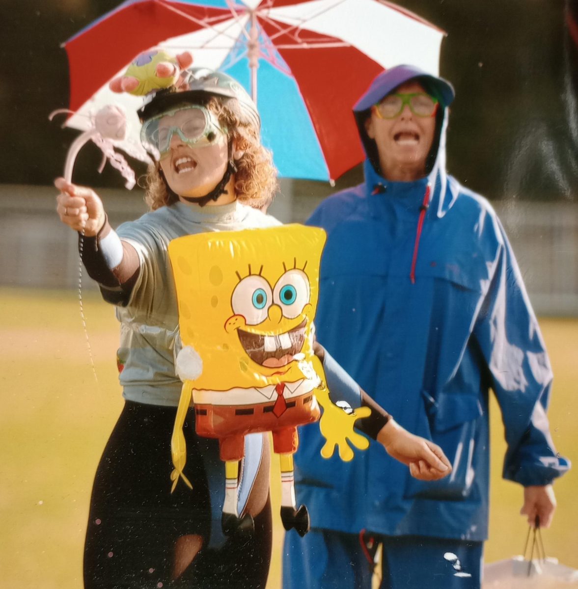 Nicholson (right) and science teacher Lisa Cochrum (left) dress up in raincoats with umbrellas, preparing to be hit by water balloons from the physics students.