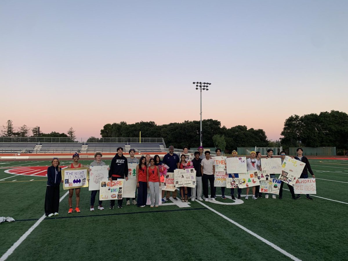 The track and field team poses for a photo during their Despicable Me-themed senior night.