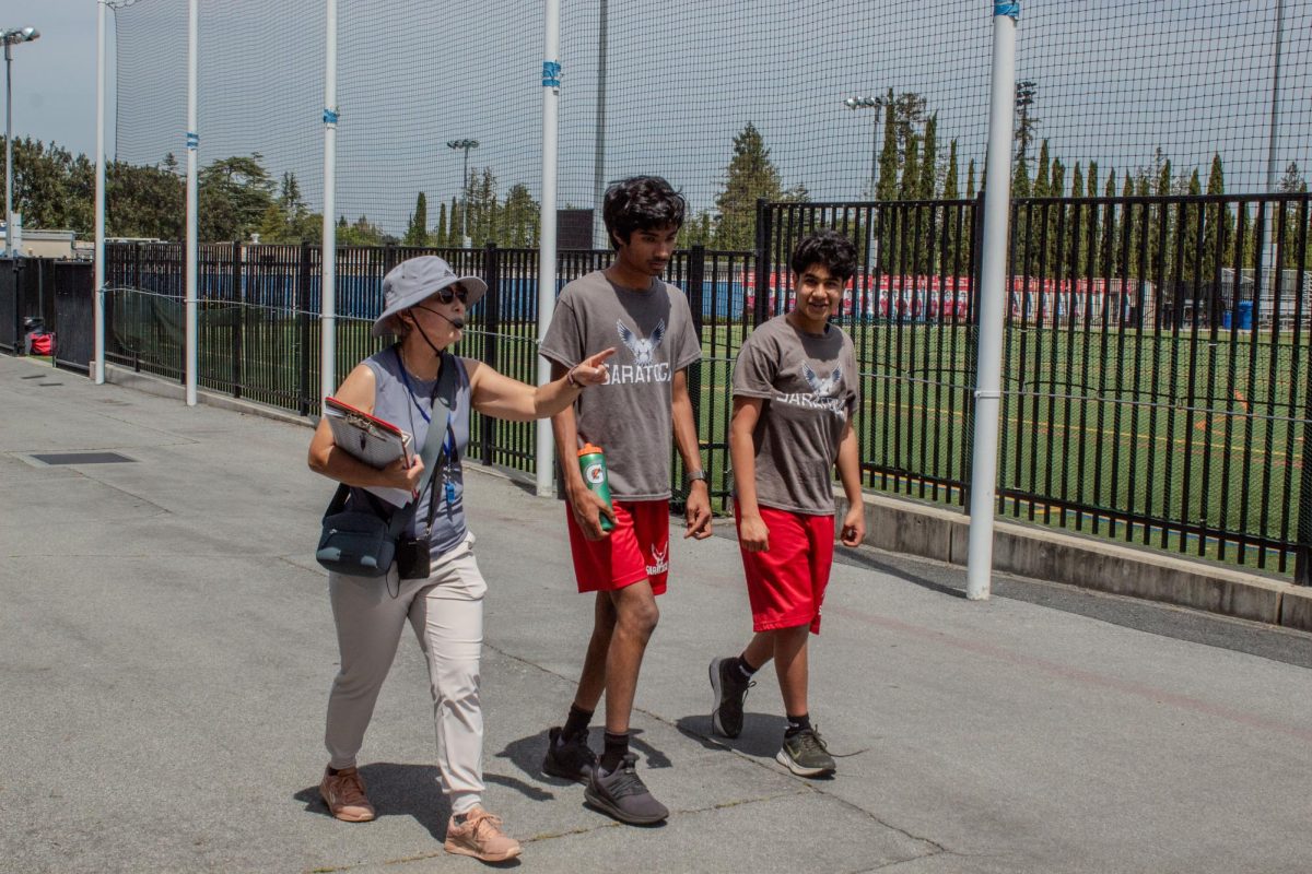 Aoki leads her students Aditya Cheethirala and Dhruva Rao to the weight room to do a workout.