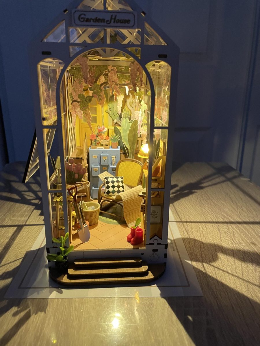 The completed Garden House book nook, featuring miniature details and warm lighting.